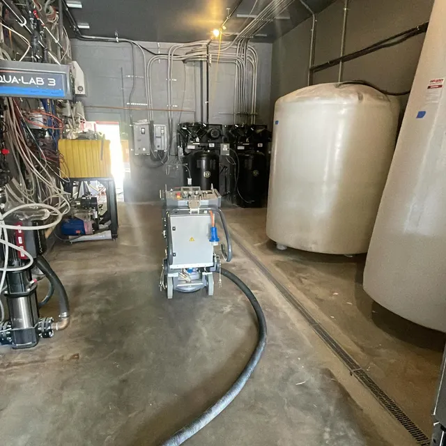 Concrete floor grinding equipment prepping a commercial slab