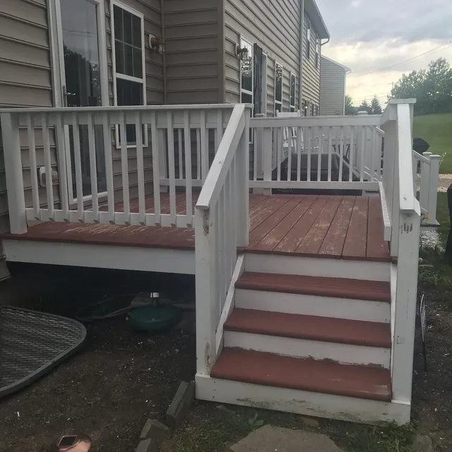 Backyard deck before refinishing, with worn and peeling red stain on the boards