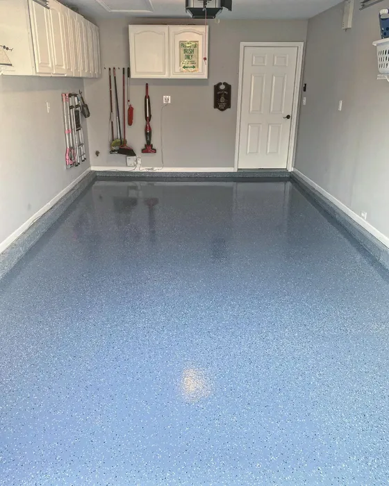 Residential garage with a glossy blue-and-white flake epoxy floor