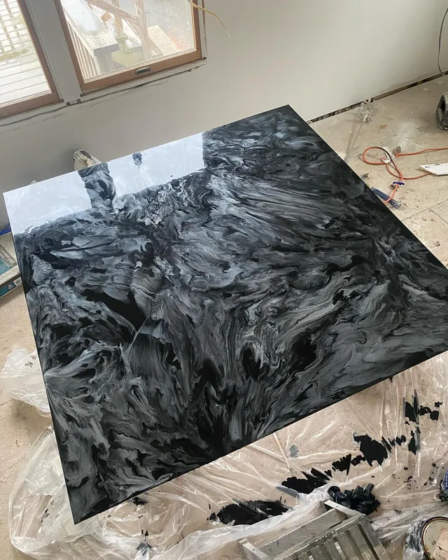 Black-and-silver metallic epoxy pour on a tabletop with a marbled, glass-smooth finish