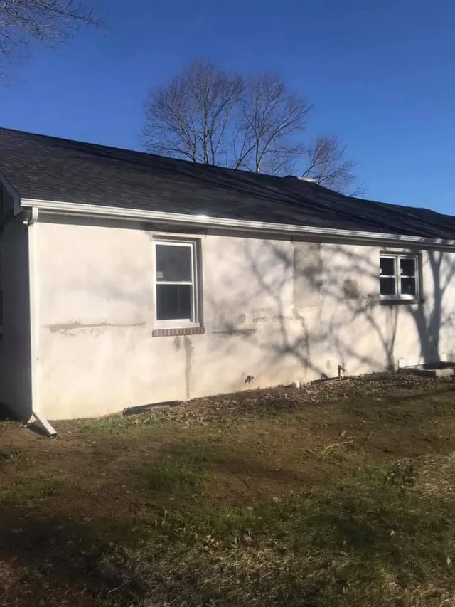 Weathered stucco house exterior before pressure washing and repaint