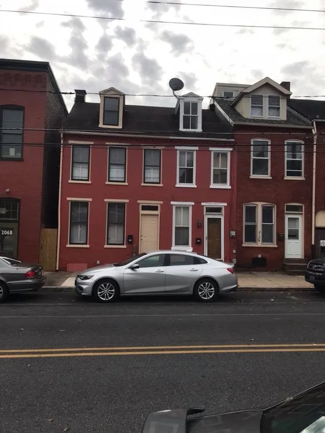 Red-brick rowhome exterior painting job in a tri-state urban neighborhood