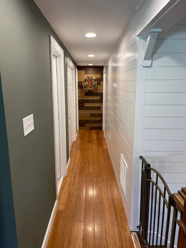 Finished hallway with painted shiplap wall and wood trim