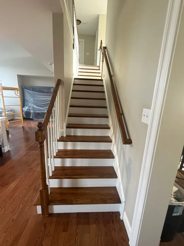 Staircase mid-refinish with scaffolding and covered furniture