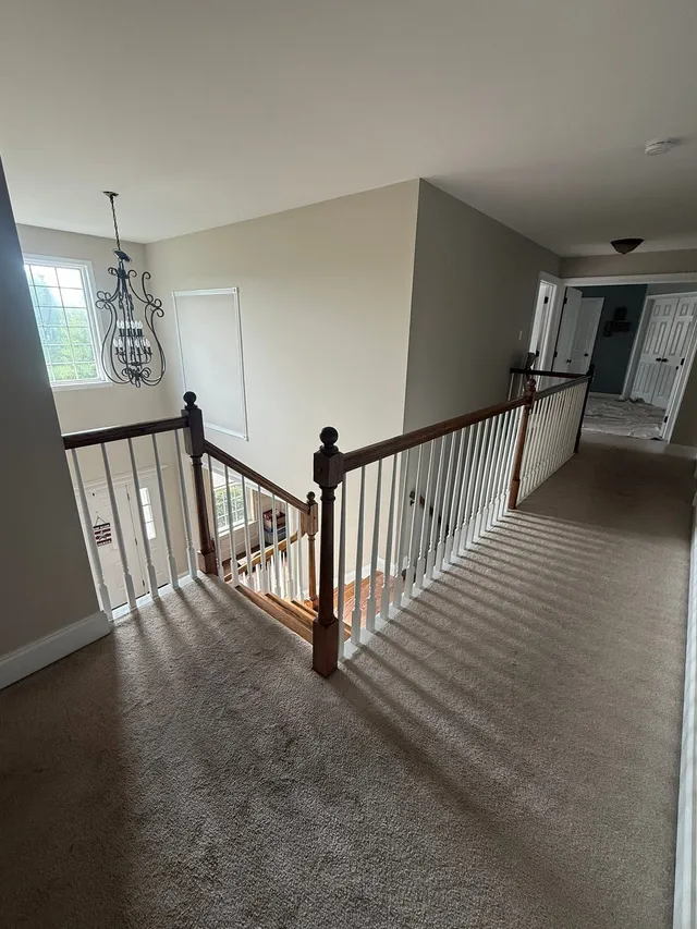 Upstairs landing over a foyer with white-painted railings, finished